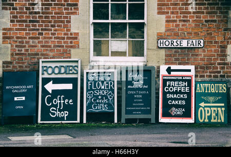 Magasin du village et enseignes de pub alignés sur le trottoir. Deddington, Oxfordshire, Angleterre. Vintage filtre appliqué Banque D'Images