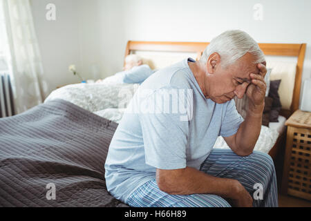 Frustrés senior man sitting on bed Banque D'Images
