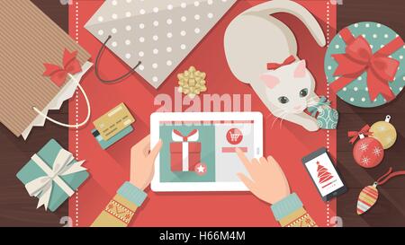 L'achat en ligne femme cadeaux de Noël à l'aide d'un comprimé, son chat est en train de jouer avec un hochet sur le bureau, maison de vacances et fêtes b Illustration de Vecteur