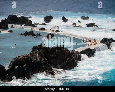 Les touristes et les populations locales bénéficient d'une baignoire en plein air d'eau de mer de l'Océan Atlantique piscines naturelles de Porto Moniz, Madeira Banque D'Images