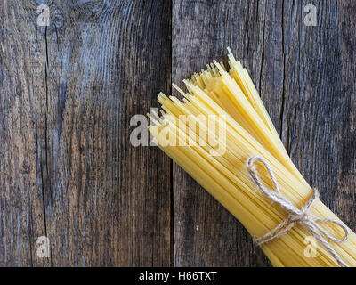 Spaghetti crus sur old weathered wooden table Banque D'Images