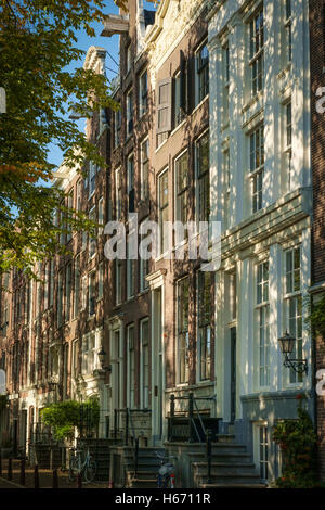 La lumière du soleil pommelé falls sur la façade de vieilles maisons de marchands d'Amsterdam. Banque D'Images