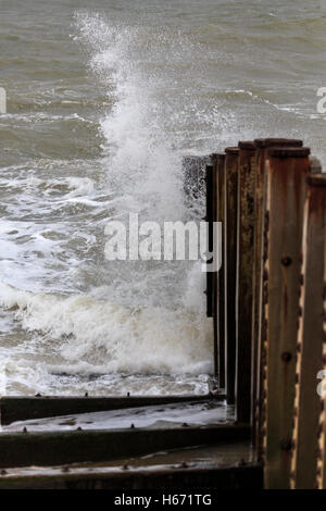 De vagues se brisant sur la plage de galets et de vieux épis Banque D'Images