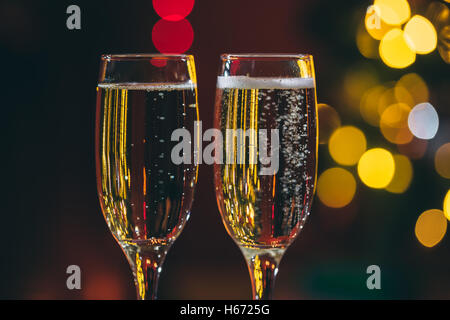 Belle deux verres de champagne debout sur la table en arrière-plan d'une chambre avec un trouble de l'arbre de Noël et décoration Banque D'Images