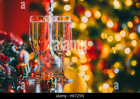 Belle deux verres de champagne debout sur la table en arrière-plan d'une chambre avec un trouble de l'arbre de Noël et décoration Banque D'Images