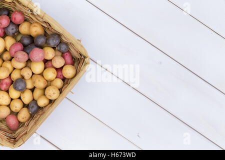 Panier en osier rempli de pommes de terre mini bébé frais au marché de fermiers prêts à rôtir ou bouillir dans leurs blousons, vo Banque D'Images