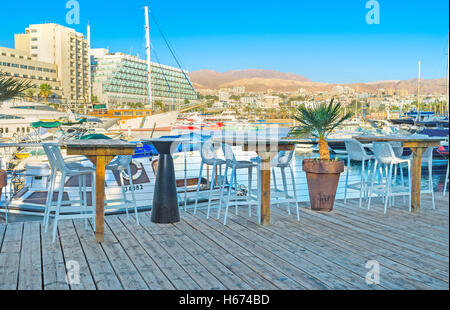 L'agréable café en plein air sur la terrasse en bois en marina avec la vue sur le livre blanc des yachts, Eilat Banque D'Images