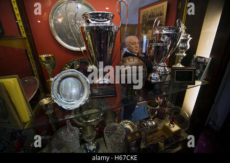 Secrétaire du Club Ricky Rea règle le cabinet trophée afficher dans la salle de réunion à l'ovale, Belfast, photographié avant Glentoran ville hôte-rivaux Cliftonville dans un match de première division NIFL. Glentoran, formé en 1892, ont été fondées à l'Ovale depuis leur formation et sont historiquement l'un de l'Irlande du Nord des deux grands clubs de football. Ils avaient une unprecendentally mauvais début de la ligue en 2016-2017, campagne mais venaient de derrière pour gagner ce luminaire 2-1, suivi par une foule de 1872. Banque D'Images