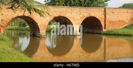 Pont médiéval fait de brique rouge avec trois arches sur la rivière en Europe Banque D'Images