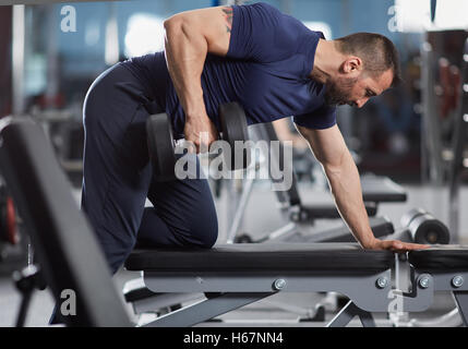 Man doing dumbbell consécutives de retour d'entraînement dans le gymnase Banque D'Images