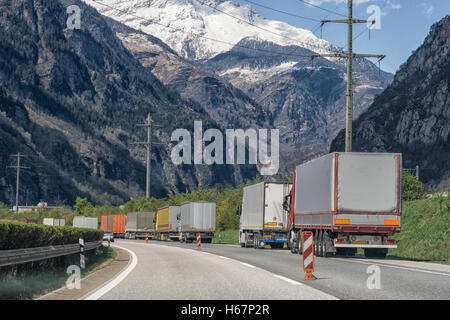 Les camions attendent en ligne pour l'ouverture de tunnel du Saint-Gothard en Suisse avec le mont Saint-Gothard en arrière-plan Banque D'Images