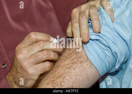 Médecin met la seringue dans le bras velus mâles Banque D'Images