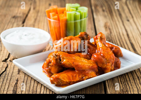 Buffalo aile de poulet avec sauce au poivre de cayenne servi chaud avec des bâtonnets de céleri et de bâtonnets de carottes avec vinaigrette au fromage bleu Banque D'Images