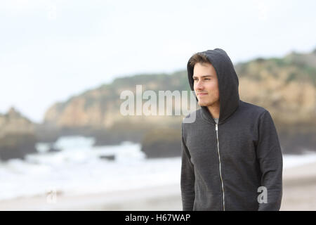 Portrait d'un certain adolescent marche sur la plage, dans un jour de pluie Banque D'Images