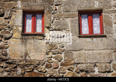 Détail de maison rurale en pierre avec deux fenêtres en bois typique Banque D'Images