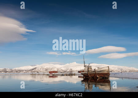 Vieux bateau sur le lac, près de la montagne en hiver Banque D'Images