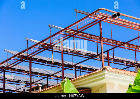 Des panneaux solaires sur un cadre métallique sur le toit d'un bâtiment dans un climat chaud Banque D'Images