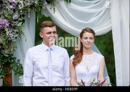 Mariés à une cérémonie de mariage sous l'arche Banque D'Images