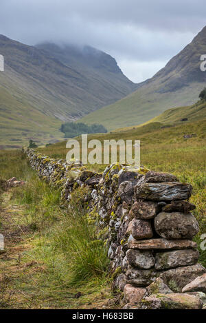 Vieux mur de pierres sèches dans les landes menant à mountain Bidean nam Bian et trois Sœurs de Glen Coe, Highlands, Scotland Banque D'Images