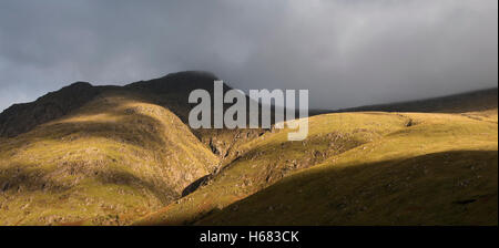 La formation de brouillard épais nuage de pluie descendant des montagnes escarpées bading dans lumière du soir, Glen Coe, Highlands, Scotland Banque D'Images