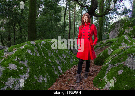 Jeune femme se sentir triste marche sur une forêt portant un manteau en hiver sous un soleil ray Banque D'Images