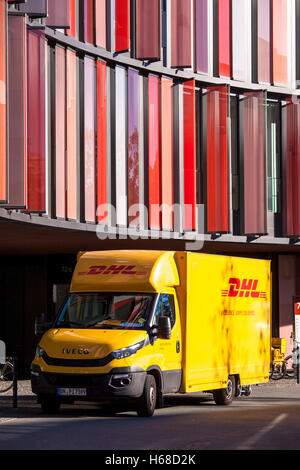 Allemagne, Cologne, service colis DHL voiture en face de l'immeuble de bureaux Bureaux ovale de Cologne. Banque D'Images