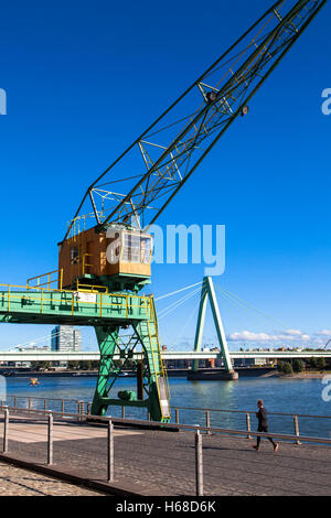 Allemagne, Cologne, vieille grue à l'Rheinau Harbour, dans l'arrière-plan le pont Severins. Banque D'Images