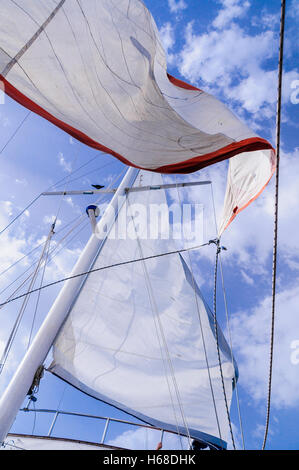 Toile Blanche voiles d'un navire à voile contre un ciel bleu avec quelques nuages. Banque D'Images