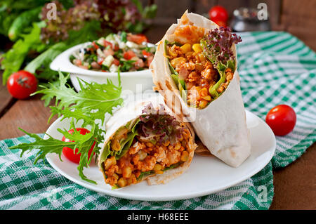Burritos wraps avec la viande hachée et de légumes sur un fond de bois. Banque D'Images