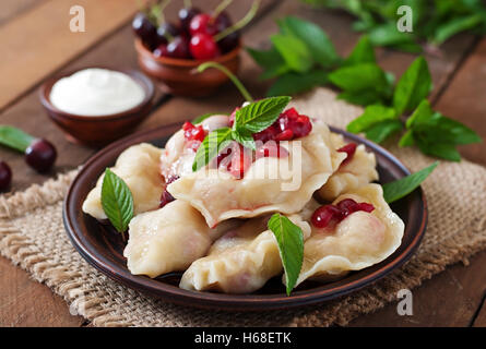 De délicieuses quenelles avec les cerises, crème aigre et jam Banque D'Images