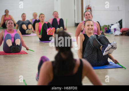 Les femmes participant à des cours de conditionnement physique, LIVRE heure tambours d'entraînement qui augmente la force de noyau, Surrey, UK Banque D'Images