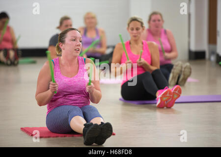 Les femmes participant à des cours de conditionnement physique, LIVRE heure tambours d'entraînement qui augmente la force de noyau, Surrey, UK Banque D'Images