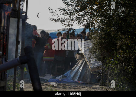 Calais, France. 25 octobre, 2016. Les gens se sont rassemblés pour regarder la cabane de brûler. Le deuxième jour de l'expulsion de la Jungle à Calais a vu le démarrage de la démolition de la jungle. Certains refuges ont été démolis par des ouvriers, tandis que d'autres refuges ont été délibérément brûlés. Crédit : Michael Debets/Pacific Press/Alamy Live News Banque D'Images