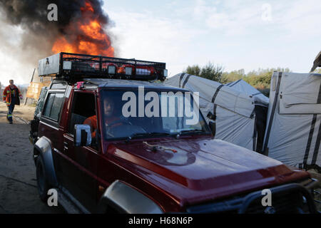 Calais, France. 25 octobre, 2016. L'agent de prévention des incendies sur les disques durs. Le deuxième jour de l'expulsion de la Jungle à Calais a vu le démarrage de la démolition de la jungle. Certains refuges ont été démolis par des ouvriers, tandis que d'autres refuges ont été délibérément brûlés. Crédit : Michael Debets/Pacific Press/Alamy Live News Banque D'Images