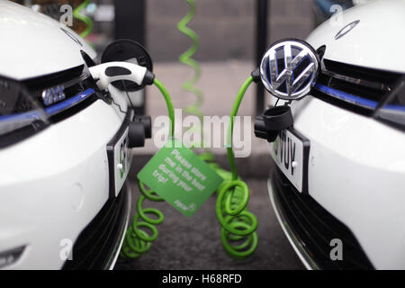 Une paire de Zipcar club l'auto-partage Volkswagen Golf GTE plug-in de voitures hybrides essence-électricité être rechargés sur une rue dans le centre de Londres. Banque D'Images