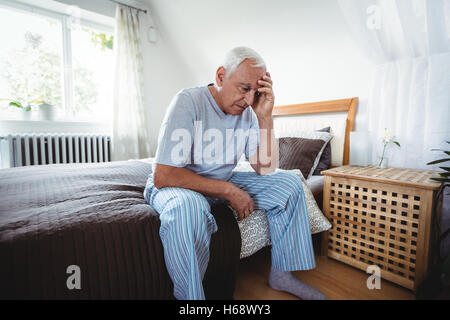 Frustrés senior man sitting on bed Banque D'Images