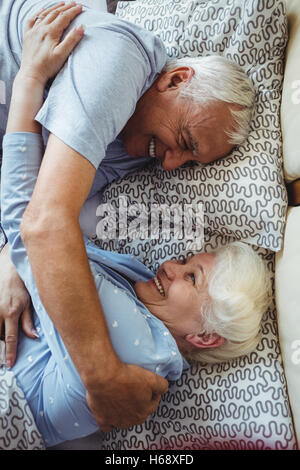 Senior couple embracing on bed Banque D'Images