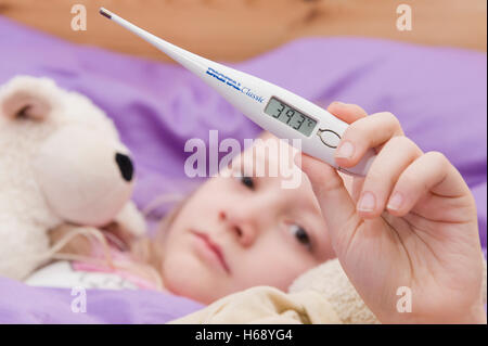 Sick girl avec thermomètre clinique au lit Banque D'Images