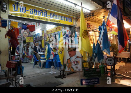 Un homme est debout dans son magasin qui vend des drapeaux thaïlandais avec un portrait du Prince Maha Vajiralongkorn de au, à Bangkok, Thaïlande. Banque D'Images