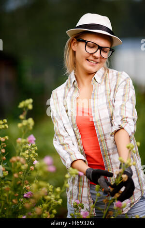 Young caucasian blonde dame jardin jardinier travaillant dans Banque D'Images