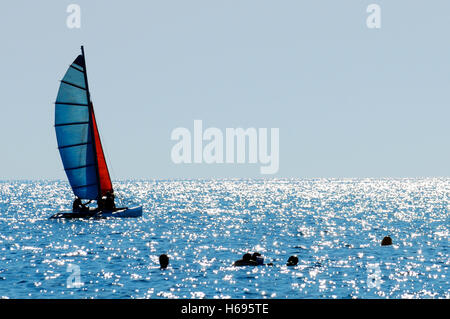 Un catamaran sur la mer bleue le long d'une côte de la mer de la Sardaigne Banque D'Images