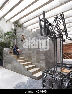 Portrait de Pedro Reyes et Carla Fernandex sur 'pyramide' avec escalier mobile art travailler en premier plan. Pedro Reyes House, Mexico, Mexique. Architecte : N/A , 2015. Banque D'Images