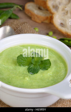 Une assiette de soupe purée de petits pois à la menthe sur une table Banque D'Images