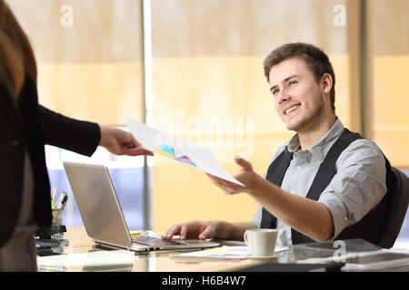 Businesswoman giving un document avec la croissance graphique à une businessman at office. Concept d'équipe Banque D'Images