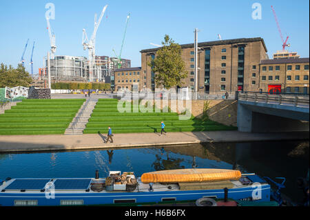 Londres - le 23 octobre 2016 : Les piétons marcher à côté du Regent's Canal en face d'un bâtiment rénové du quartier de King's Cross. Banque D'Images