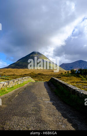 À la recherche de l'ensemble de l'arc de Sligachan un vieux pont de pierre à l'action du soleil sur la forme conique de Glamaig, le Red Hills Banque D'Images