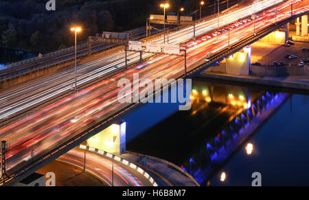 Pont routier sur la rivière la nuit, vue de dessus. light trails de voitures sur une autoroute. Embouteillage sur une longue exposition Banque D'Images