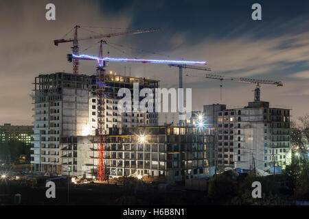 Beaucoup de grues à tour construire des bâtiments résidentiels la nuit Banque D'Images