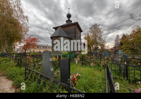 Cimetière avec ancienne église en bois sur l'arrière-plan d'un ciel d'orage Banque D'Images