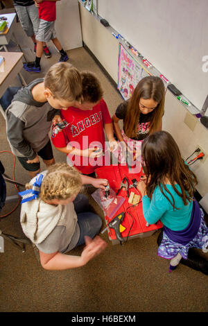 Les enfants de l'école élémentaire multiraciale enthousiaste assemblage robots comme un projet de classe à Mission Viejo, CA. Banque D'Images